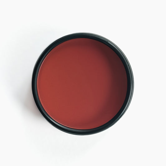 An open black aluminum tin of Nuska Strawberry Natural Lip Balm, showing the creamy texture and color of the moisturizing balm.