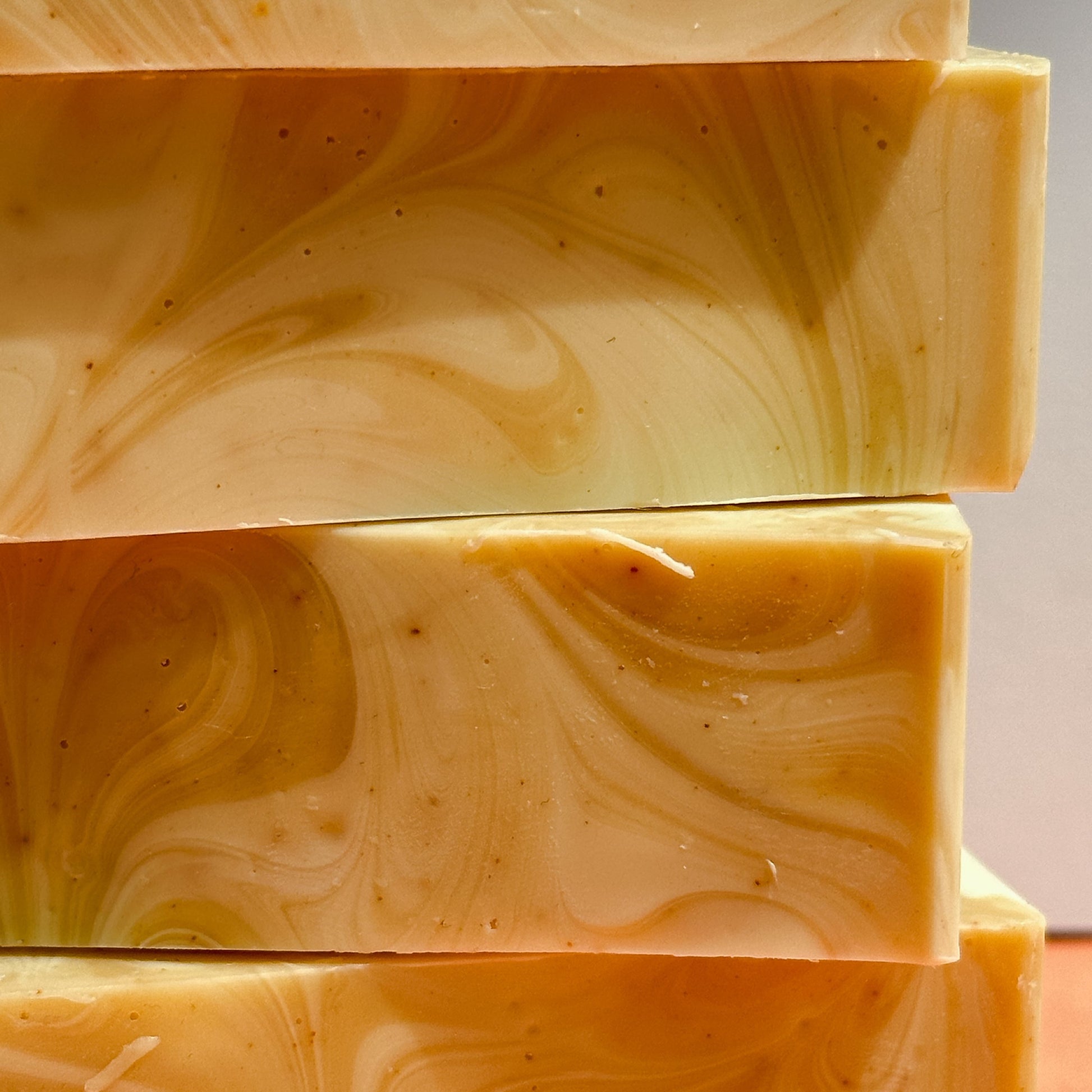 Close-up of stacked bars of Nuska Tangerine Soap with swirled orange and cream colours