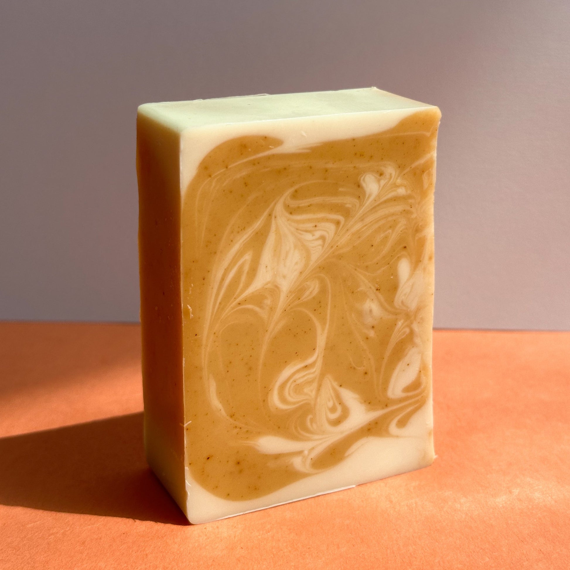 A rectangular bar of Nuska Tangerine Soap with swirled orange and cream colours.